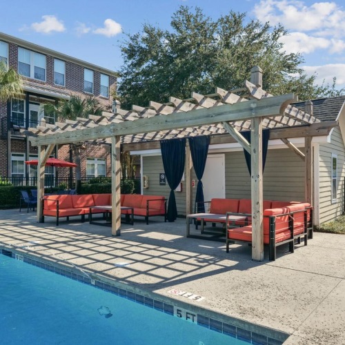 a pool with a covered area and couches
